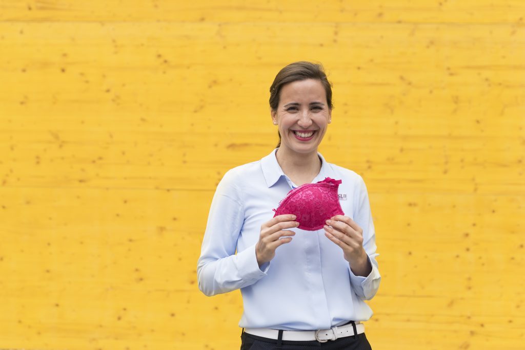 Andreia Fernandes in front of yellow Wall smiling at the audience